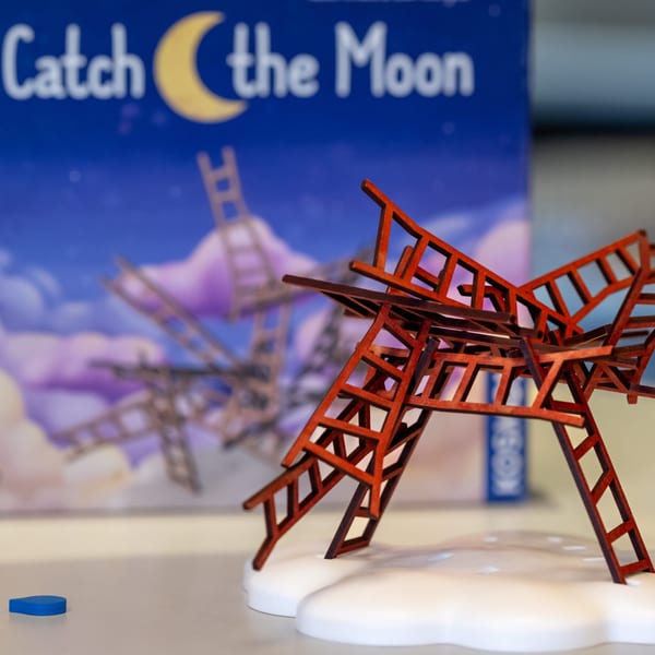 A game of "Catch the Moon" with red wooden ladders balanced on white cloud pieces.
